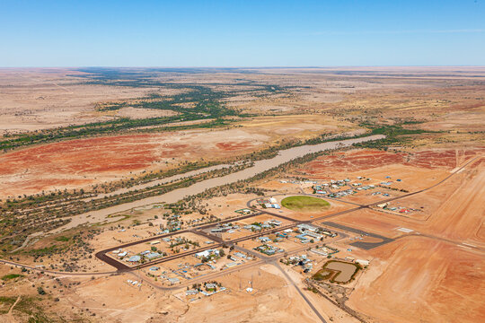 Aerial view of remote outback town Birdsville with river and desert terrain, Queensland, Australia.