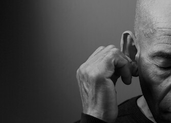 deaf man suffering from deafness and hearing loss on grey background with people stock image stock...