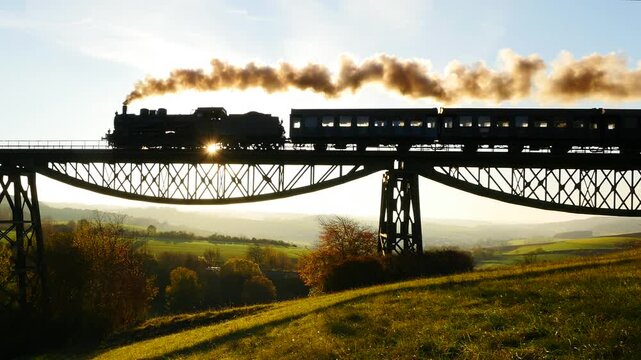 Vintage steam train crossing a bridge at sunset with beautiful views of hills and nature
