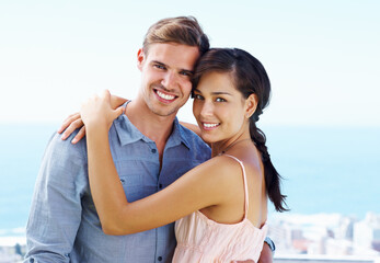 Obraz premium Happy, couple and portrait with honeymoon, love and marriage on holiday with hug outdoor. Smile, care and support of people with bonding on travel and vacation in Greece with embrace on trip by sea