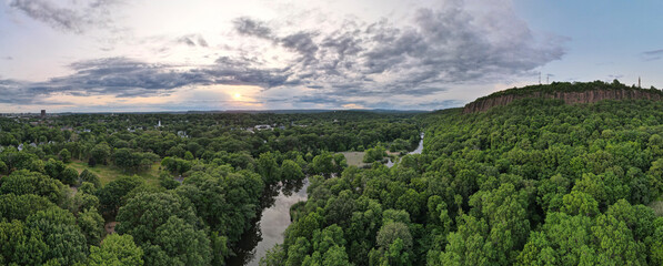 Aerial view of lush forest, river, cliff, and sky at East Rock Park, New Haven, Connecticut, United States.