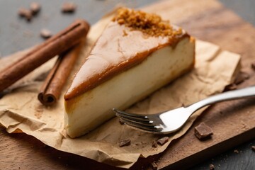 Caramel cheesecake with nuts and cinnamon on kitchen desk