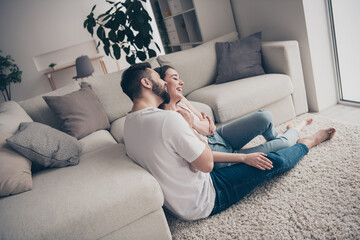 Photo of pretty cheerful lady guy wear casual looks siting floor cuddling having rest together indoors room home house