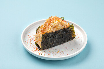 Portion of japanese onigiri snack with spices on a plate