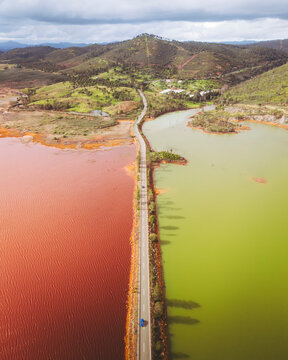 Aerial view of colorful landscape with red and green water, winding road, and mountain in Minas de Rio Tinto, Copper Mine, El Campillo, Huelva, Spain.