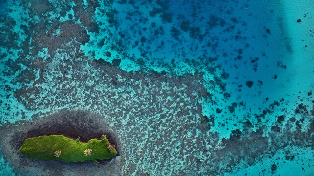 Aerial view of tranquil turquoise waters surrounding a remote tropical island, Fiji.