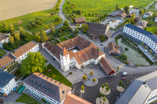 Aerial view of residential village with rooftops, roads, and greenery near Frienisberg, Bern, Switzerland.