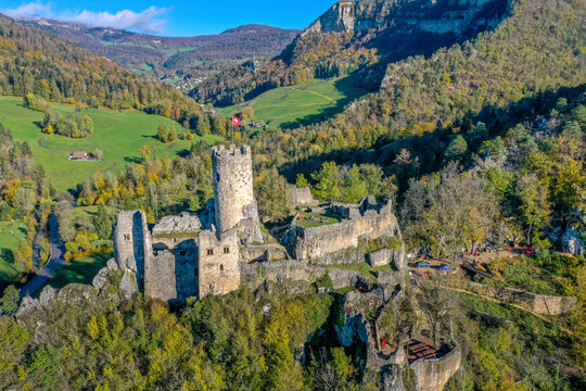 Aerial view of historic castle ruins surrounded by mountains and forest, Balsthal, Switzerland.