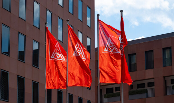 Red IGM flags IG Metall logo, German dominant metalworkers union on building, holding sign in support, Europe's largest industrial union, Frankfurt - July 22, 2024