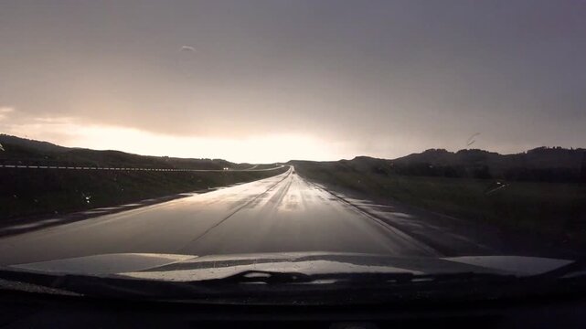 Driving on a rainy day with wet road and windshield wipers on