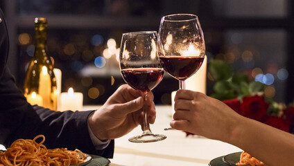 Hands holding glasses of wine on restaurant background. Let's have a toast concept