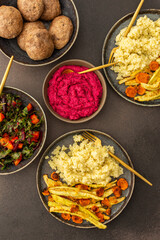 Enjoy a hearty breakfast or lunch with millet, baked zucchini, and carrots, paired with a fresh salad of seasonal vegetables and herbs, chickpea buns, beetroot hummus for a delicious vegetarian meal
