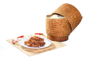 Pictures of food Thailand with sticky rice and fried pork serving with chili and onions sliced on bamboo mat with isolated concept.