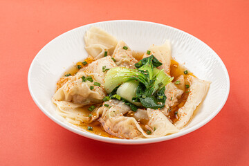 Portion of appetizing asian wonton dumplings with bok choi