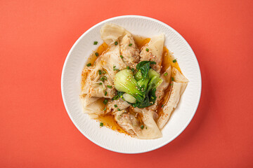 Portion of appetizing asian wonton dumplings with bok choi