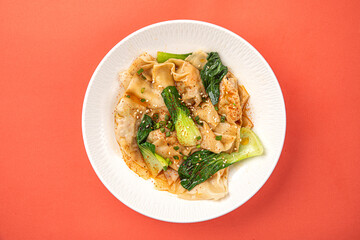 Portion of appetizing asian wonton dumplings with bok choi