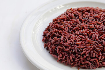 Cooked black berry rice in white plate