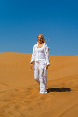 Tourist woman enjoys the sand dunes in the afternoon,