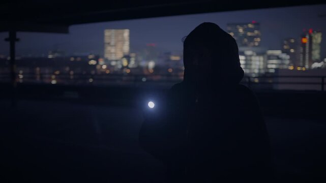 Exploring a dark urban environment with a flashlight at night, evoking solitude and mystery