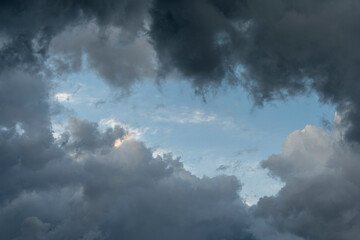 Dramatic sky background with dark rainy clouds at sunset.
