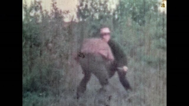 Two cowboys in knife fight in forest nature. Crime, violence in Wild West. Old western conflict historical reenactments. Angry men engage in style fistfight. Vintage color film. Retro 1960s archive