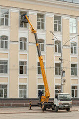 The windows of the building are being washed using an aerial platform.