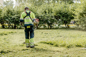 Lawn mowers cut the grass in a city park.