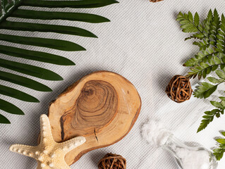 wooden piece on white towel surrounded by leves of palm tree, summer concept, space for text, spa