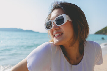 Close up of cheerful asian woman happy to be outdoor on the beach.