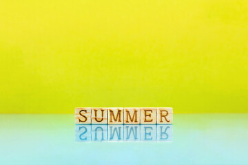 SUMMERの英語ブロックが水面にうつる黄色の明るい背景