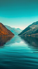 Obraz premium A serene lake reflecting the surrounding mountains under a clear blue sky