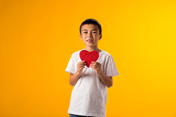 Kid boy holding paper heart. Love and valentine day and gratitude concept
