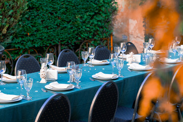 served table banquet dishes plates cups outdoor garden back street environment space with orange blurred autumn foliage without people