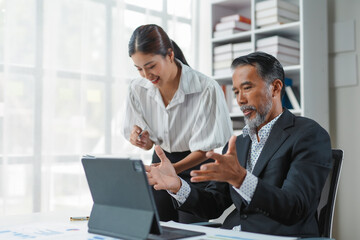 Team of professionals using a digital tablet to analyze data, strategize, and collaborate during a productive office meeting