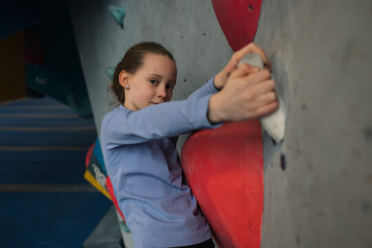 portrait of a child bouldering at an indoor climbing centre