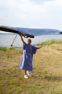 A woman carries a wing for foiling.