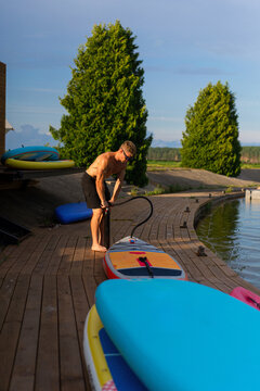 Man pumps up inflatable SUP.