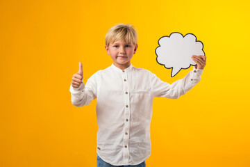 Child boy holding think cloud bubble card and pointing finger up. Dreaming and idea concept