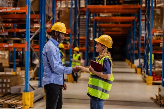 Gender Equality in the Workplace: Male and Female Warehouse Workers Shaking Hands