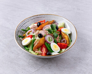 Salad with canned tuna, salad nicoise, on a gray background for a food delivery site menu