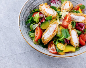 salad with panko shrimp, avocado and mango on a gray background for the restaurant menu,