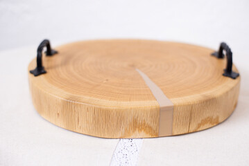 Wooden kitchen board. Epoxy resin tray on the table. Wooden slice of walnut. Circle