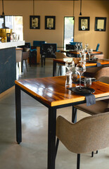 close-up photo of a meticulously set table in a modern restaurant. The table features a rich, dark...