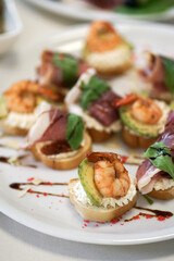 Sandwiches with greens and shrimp on a white plate.