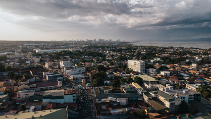 Aerial View of Dense Urban Sprawl and Busy Main Street under Dramatic Sky in San Pedro, Laguna,...