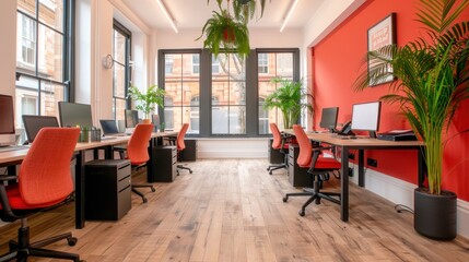 Fototapeta premium Spacious modern office with red chairs, large windows, and plants, offering a vibrant workspace with ample natural light and contemporary design.