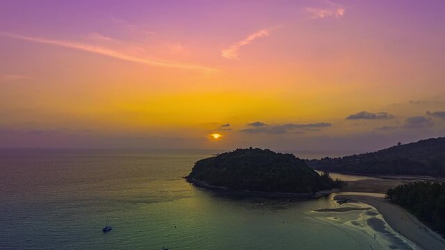aerial hyperlapse the sun above Kala island at Layan beach Phuket.
colorful sky of sunset at horizon.Phuket beach sea Amazing beach, 
Beautiful beach Phuket Thailand, Nature and travel concept.