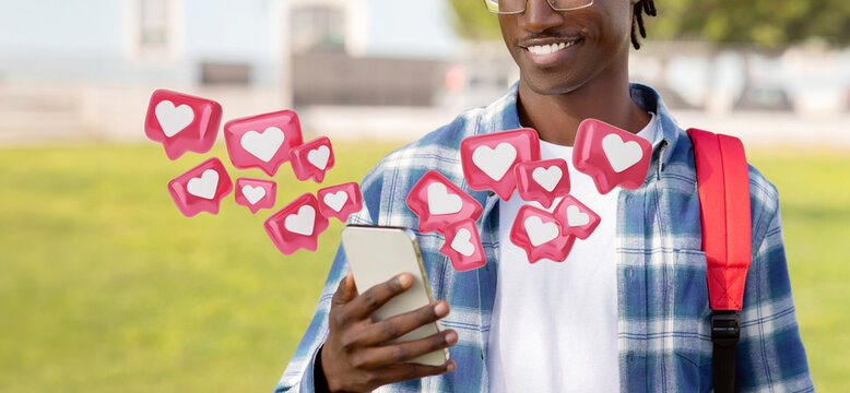Cropped of young black man wearing a plaid shirt and a backpack is using his smartphone outdoors. He is smiling and looking at his phone screen. Digital hearts are floating around him