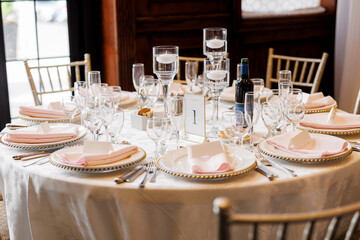 Round table setting is number one in the restaurant. The table is decorated with floating candles. Preparing the table in the restaurant for receiving guests. Wedding banquet