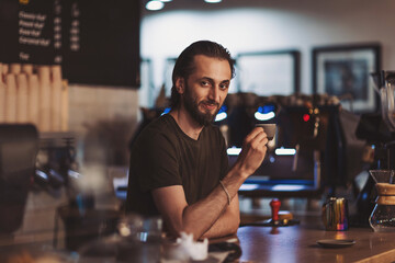 Pleasant barista drinking coffee. Happy male barista drinking coffee in cafe. cafe, free time and city concept. enjoying coffee break while relaxing. 